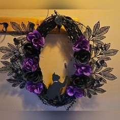 a purple and black wreath hanging on the wall