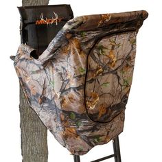 a hunting blind attached to a tree stand with the cover over it's back