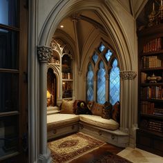 a room with a large window and lots of books on the shelves