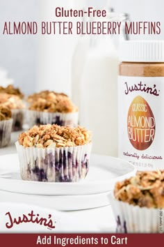 blueberry muffins on a white plate next to a bottle of almond butter