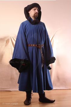 This garment is inspired by the depiction of the Duke of Berry ("Très Riches Heures du Duc de Berry" 1412-1416, Musée Condé, France). The houppelande (houp) was an extensive  outer garment for men and women in medieval Europe. Men wore a houpe with a belt.  It can also be worn without a belt. With a high belt is houppelande a ceremonial gown of a noblewoman. Open bag sleeves are wide and long,  often decoratively cut at the edges (grande bombarded)  or decorated with fur. The width of the sleeve Blue Medieval Dress With Historical Design, Medieval Blue Dress With Historical Design, Historical Dresses For Medieval Festivals Costume Party, Historical Dresses For Medieval Festivals, Medieval Costume Blue Dress, Viking Costume Dress For Medieval Festivals, Historical Dresses For Larp And Medieval Festivals, Historical Dresses For Medieval Festivals Cosplay, Historical Dresses For Cosplay At Medieval Festivals