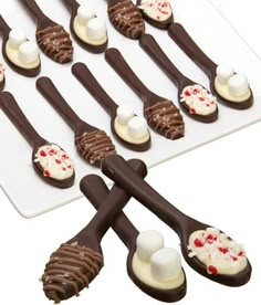 chocolate spoons with marshmallows on them are arranged in the shape of hearts