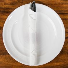 a white plate with a napkin on it and a fork sticking out of the end