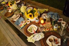 a picnic table is set with sunflowers and other items for the guests to enjoy