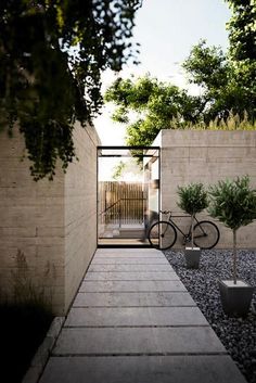 a bike is parked in the middle of a walkway between two concrete walls and trees