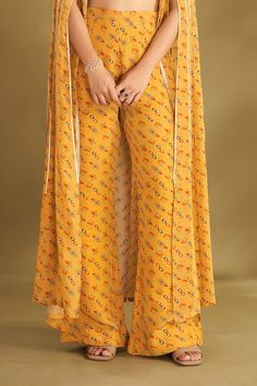 Dandelion yellow cape with floral, ikat print and zari thread, sequin embroidered panel. Paired with printed blouse and flared pant. - Aza Fashions Bollywood Style Pant Set With Sheer Dupatta For Festivals, Traditional Front Open Palazzo Set For Diwali, Festive Dabka Pants For Festivals, Traditional Pant Set With Printed Motifs For Wedding, Traditional Wedding Pant Set With Printed Motifs, Zari Work Straight Pants Sets, Full Length Anarkali Set For Eid, Full Length Festive Kurta, Eid Full Length Dupatta