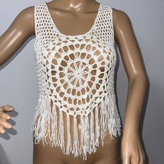 a mannequin wearing a white crochet top with fringes on it