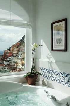 a bathroom with a large jacuzzi tub next to a window overlooking the ocean