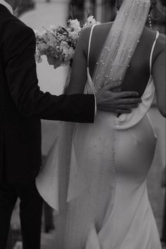 black and white photograph of a bride walking with her groom