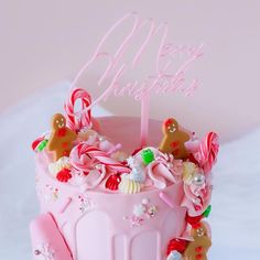 a pink birthday cake with candy and candies on it's top is shown