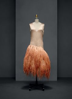 Louiseboulanger (French, 1878–1950) . Evening Dress, 1928, Haute Couture. Machine–sewn, hand–finished beige silk satin, hand–embroidered with natural straw; hand–appliquéd with panels of silk tulle with hand–stitched ombré–dyed ostrich plumes, hand–knotted in strands of three. Photo © Nicholas Alan Cope. #ManusxMachina #CostumeInstitute Twenties Style, Beige Silk, 20th Century Fashion, Silk Tulle, Couture Mode