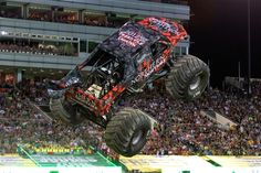 a monster truck is in mid air over the crowd