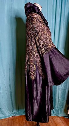 a woman's dress on display in front of a blue curtain and wooden floor