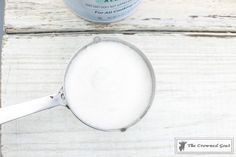 a wooden table topped with a metal pan filled with white powder next to a bottle of toothpaste