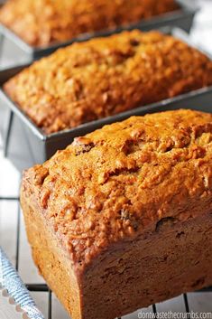 three loafs of banana bread sitting on top of a cooling rack