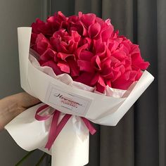 a person holding a bouquet of pink flowers