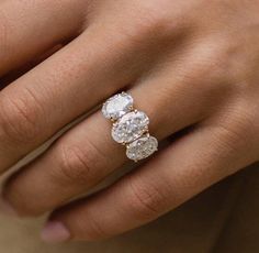 a woman's hand with three diamond rings on her fingers and the ring is white gold