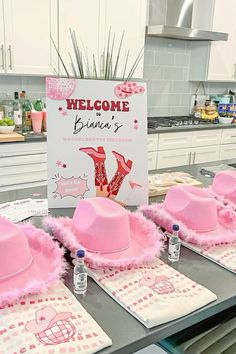 pink hats and napkins sitting on top of a counter next to a welcome sign