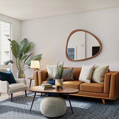 a living room filled with furniture and a large mirror on the wall above it's windows