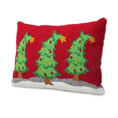 a red pillow with green christmas trees on the front and bottom, sitting on a white surface