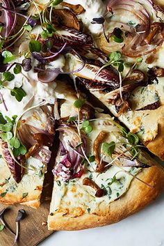 a pizza with onions, cheese and herbs on it