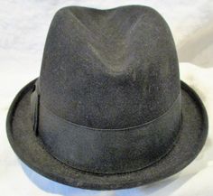 "I don't know anything about hats, so what I'm about to describe to you will be a challenge for me. Please bear with me, and if you see egregious errors or can enlighten me, I'd sure appreciate learning from the experts on Etsy! This appears to me to be a men's hat, 100% felted wool in a luxurious black color and the hat is marked \"KENWORTH\" and \"Imperial Finish\". It looks like a classic fedora hat, and has that wonderful mid century retro look. Nice ribbon detail and muted red and deep blue Vintage Fedora Felt Hat, Vintage Fedora Hat, One Size Fits Most, Fitted Vintage Cap, Formal Winter Cap Hat, Winter Formal Cap Hat, Formal Winter Cap, Vintage Brimmed Top Hat, Vintage Fedora With Curved Brim, Vintage Short Brim Top Hat