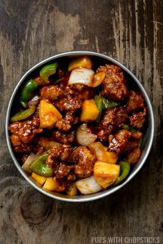 a metal bowl filled with meat and vegetables