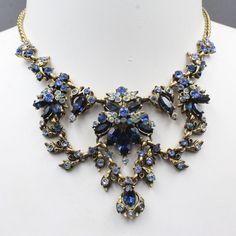 This Fabulous Hollycraft Necklace Features Dark And Light Blue Glass Rhinestones Set In A Brass Tone Metal. This Necklace Lay Flat On The Chest. It Is In Gorgeous Condition With Slight Patina And Wear. This Piece Measures 15 1/2" Long. The Center Part Is 5 1/2" Wide And The Drop Is 2 1/2". Stock Code: 3bp2210-2-8 Blue Formal Jewelry With Stones, Formal Blue Jewelry With Stones, Formal Blue Stone Jewelry, Blue Crystal Jewelry With Rhinestones, Sapphire Necklace For Party, Vintage Blue Necklace For Evening, Blue Stone Necklace For Formal Occasions, Elegant Blue Necklace With Jewels, Elegant Blue Rhinestone Necklace Gift