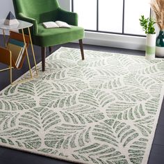 a green chair sitting in front of a window next to a white rug on top of a hard wood floor