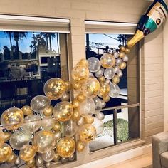 the balloon arch is decorated with gold and silver balloons