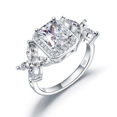 an engagement ring with three stones on the side and two diamonds at the top, set in