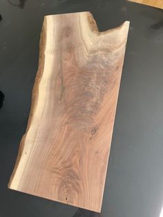 a piece of wood sitting on top of a black table next to a computer mouse