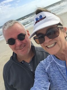 an older couple taking a selfie on the beach