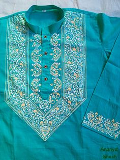 a blue shirt with an embroidered design on it