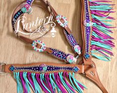 two different colored leather belts with fringes and beads on the sides, one has a buckle