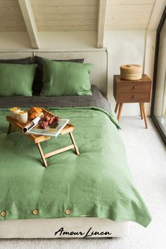 a tray with food sitting on top of a bed in a bedroom next to a night stand