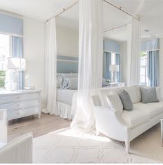 a living room with white furniture and curtains