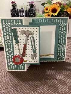 an open card with tools on it sitting on a table next to sunflowers