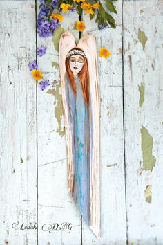 a painting of an angel with long hair and flowers on the side of a wooden wall