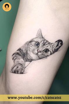 a small cat tattoo on the thigh, with an eyeball in it's mouth