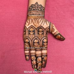 a woman's hand with henna tattoos on it