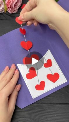 someone is making a card with hearts on it