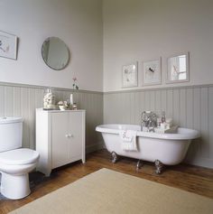 a bathroom with white fixtures and wood floors