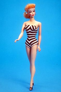 a woman in a black and white striped swimsuit is posing for a photo on a blue background