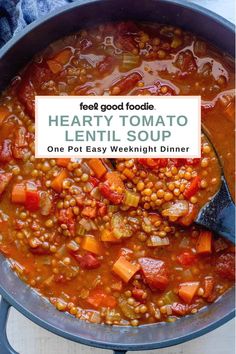 hearty tomato lentil soup in a blue pot with a spoon on the side