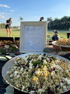 a plate full of food sitting on top of a table with people in the background