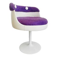 a purple and white chair sitting on top of a white pedestal