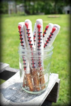 there are many toothbrushes in the jar on the picnic table with grass behind them