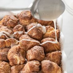 cinnamon rolls are being drizzled with icing