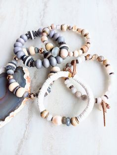 Earthy, natural, cozy, and everyday. Beautiful beige, white, cream, brown, and touches of sienna and rust in these mixed medium stack bracelets. Several gemstone varieties in different sizes, finishes, and colors. Several Agates, AA Labradorite, Pearls, Jasper, Gold Hematite, Riverstone, Fossilized Coral, Jade rondelle, and many ethical bone beads in a variety of colors and shapes. Mix these in with recycled glass, wood rondelle, Pave diamond wheel, shell, coconut disks, and mixed metals. Unique Bohemian White Bracelets For Everyday, White Earthy Everyday Jewelry, Earthy Everyday White Jewelry, Rustic Brown Beaded Bracelets For Everyday, Rustic Brown Beaded Bracelets For Everyday Wear, Rustic Handmade Beaded Bracelets For Everyday Wear, Rustic Handmade Beaded Bracelets For Everyday, Stack Bracelets, Start Running